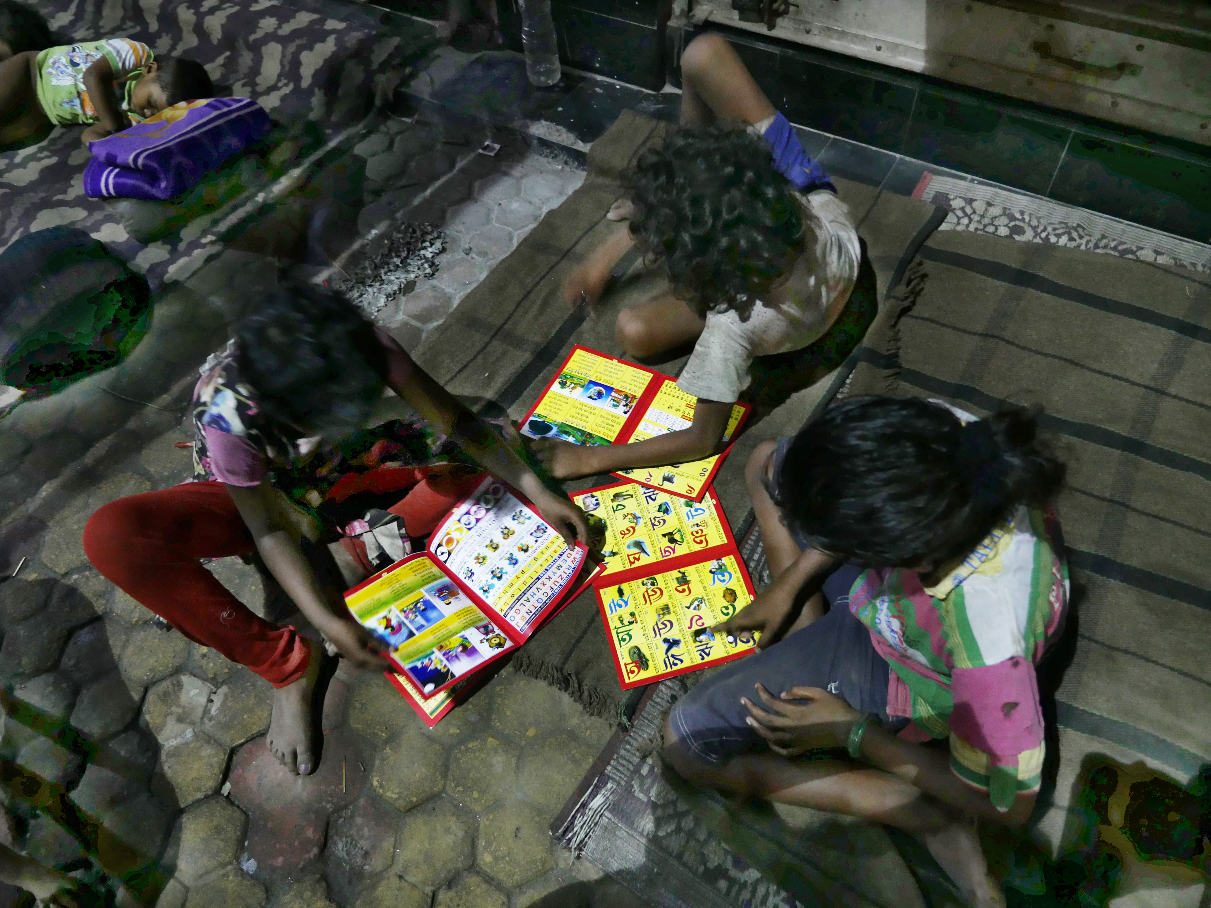 Children poring over books of figures and alphabets.