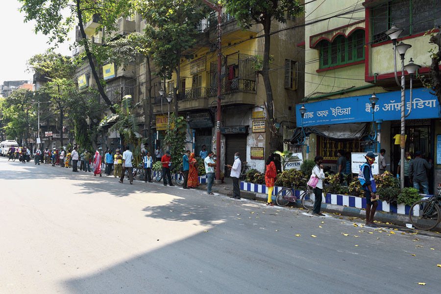 People follow social distancing while queueing up to enter a bank on Bhupen Bose Avenue, 
near Shyambazar, on Friday