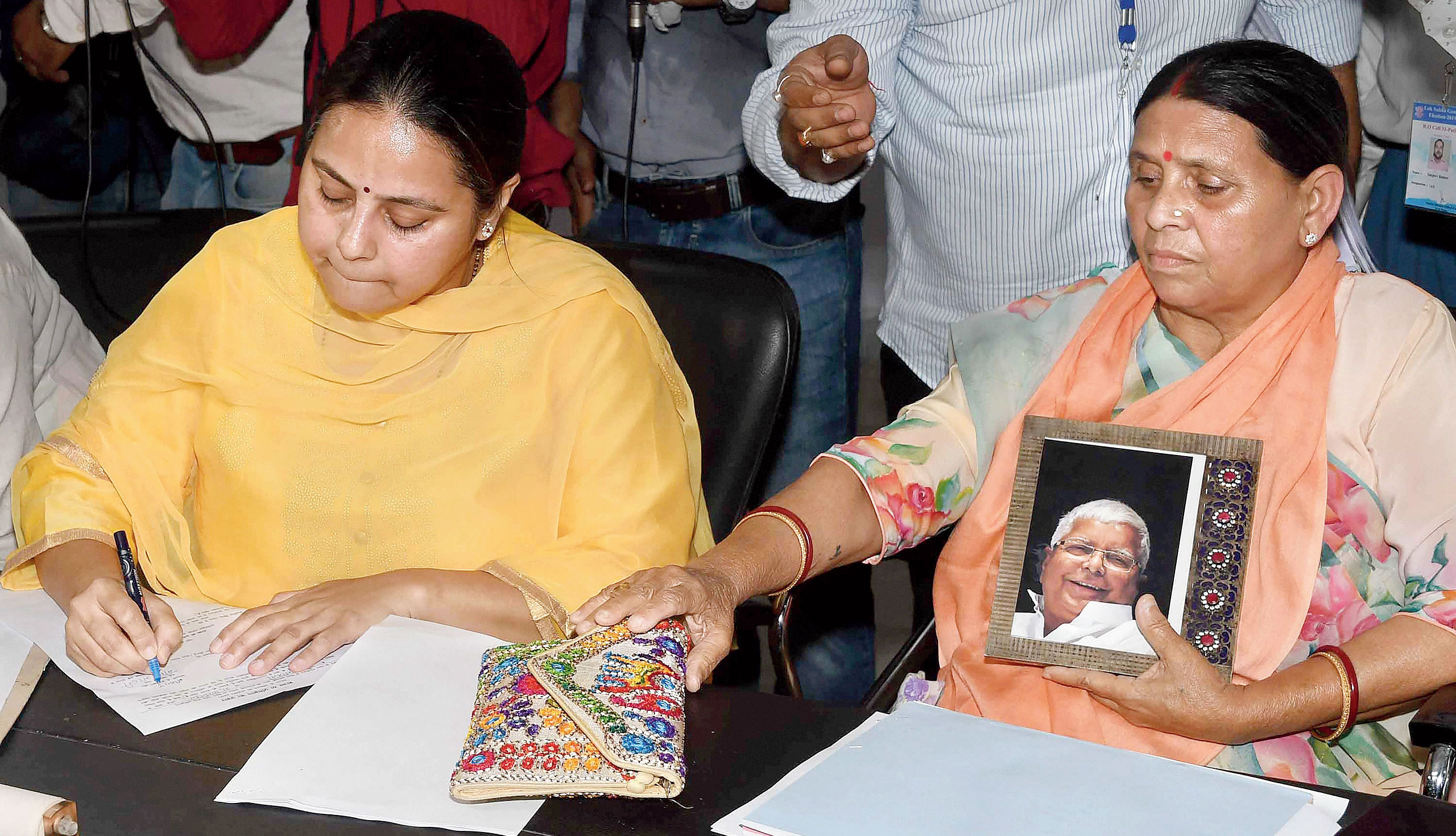 Rabri Devi sits with a photograph of Lalu Prasad while daughter Misa Bharti (left) files her nomination papers in Patna on April 25. 