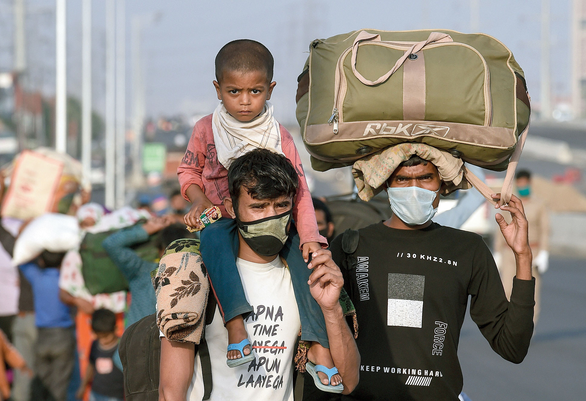 A child on his shoulders, a migrant and others walk in Delhi  towards Uttar  Pradesh on Monday.