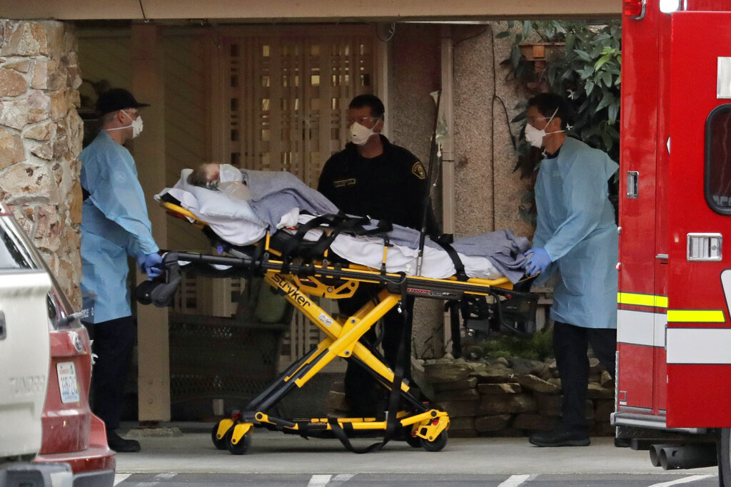 A patient is loaded into an ambulance, Tuesday, March 10, 2020, at the Life Care Center in Kirkland, Wash., near Seattle.