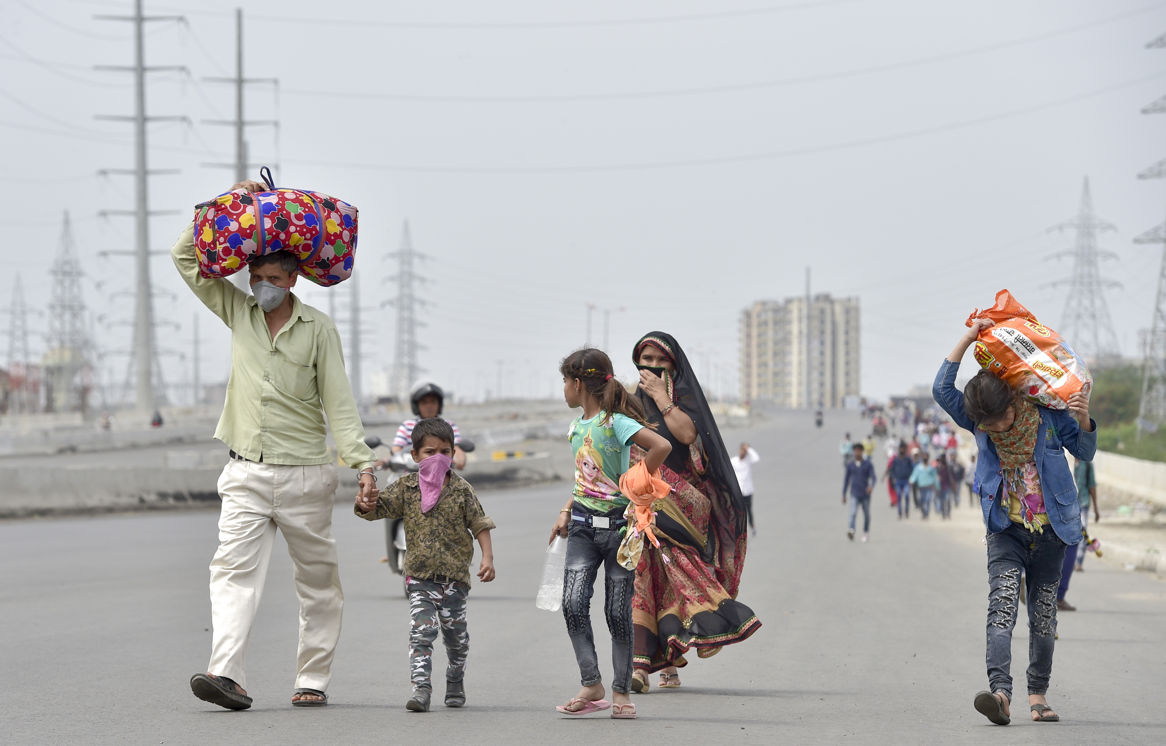People return to their native place on foot due to absence of any means of transportation during day-2 of a nationwide lockdown, imposed in the wake of coronavirus pandemic, in Ghaziabad, Thursday, March 26, 2020
