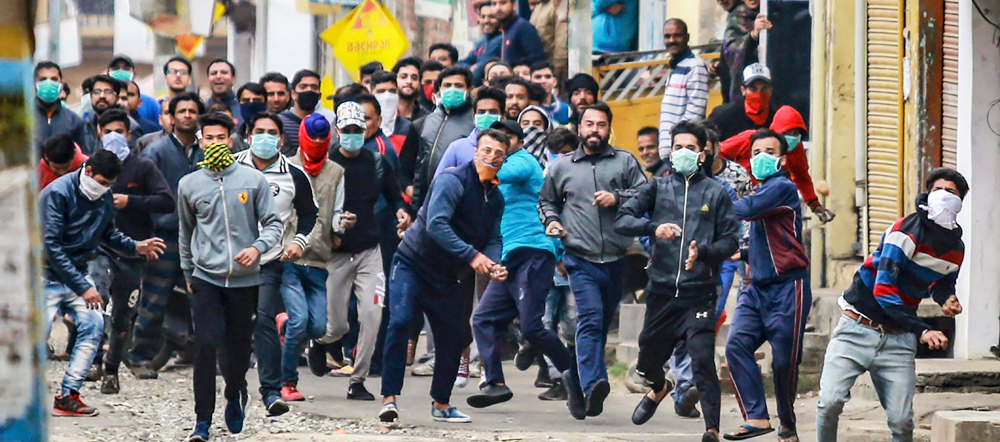 Protestors clash with police personnel during a curfew, imposed on the third day after the clash between two communities over the protest against the Pulwama terror attack, in Jammu, on Sunday.