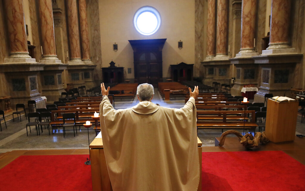 Don Angelo Riva celebrates a mass in an empty church after Italy's lockdown measure to prevent the spread of Covid-19, in Carenno, Italy, Thursday, April 2, 2020.