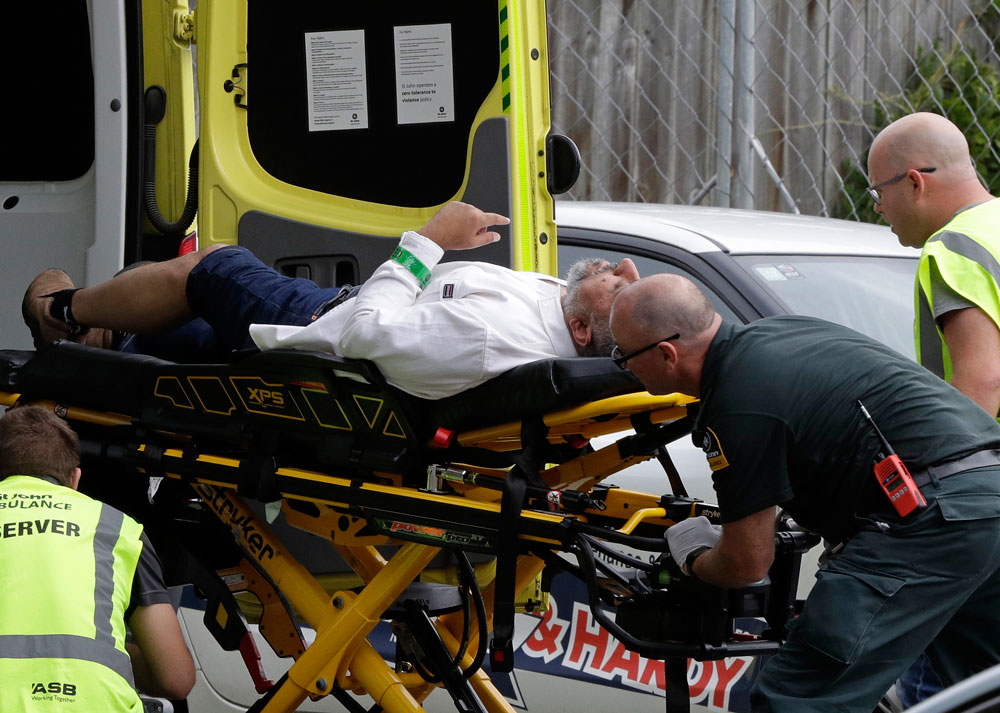 Ambulance staff take a man from outside a mosque in central Christchurch, New Zealand, on Friday