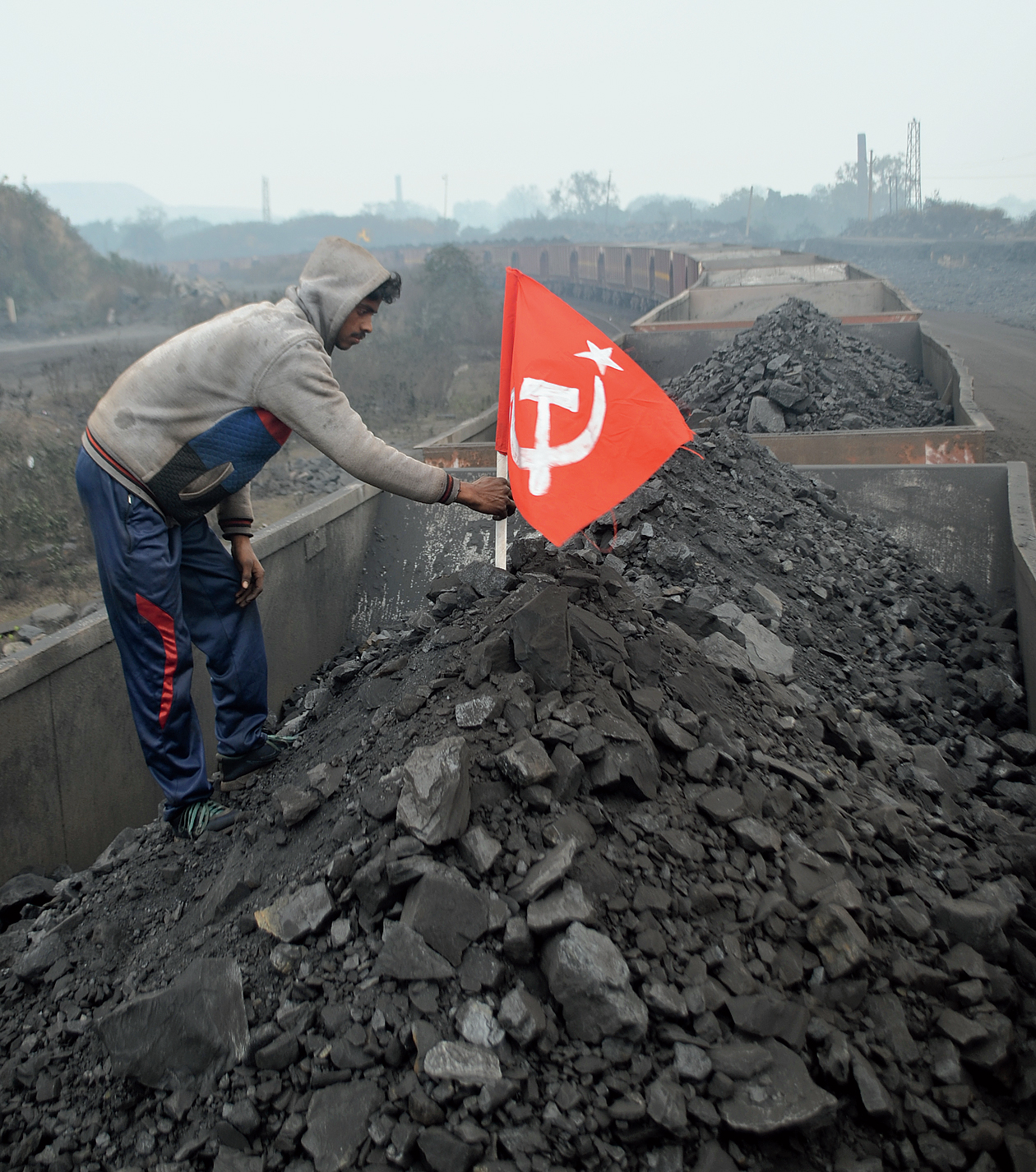 A coal worker plants a flag on a wagon in Jharia, Dhanbad.