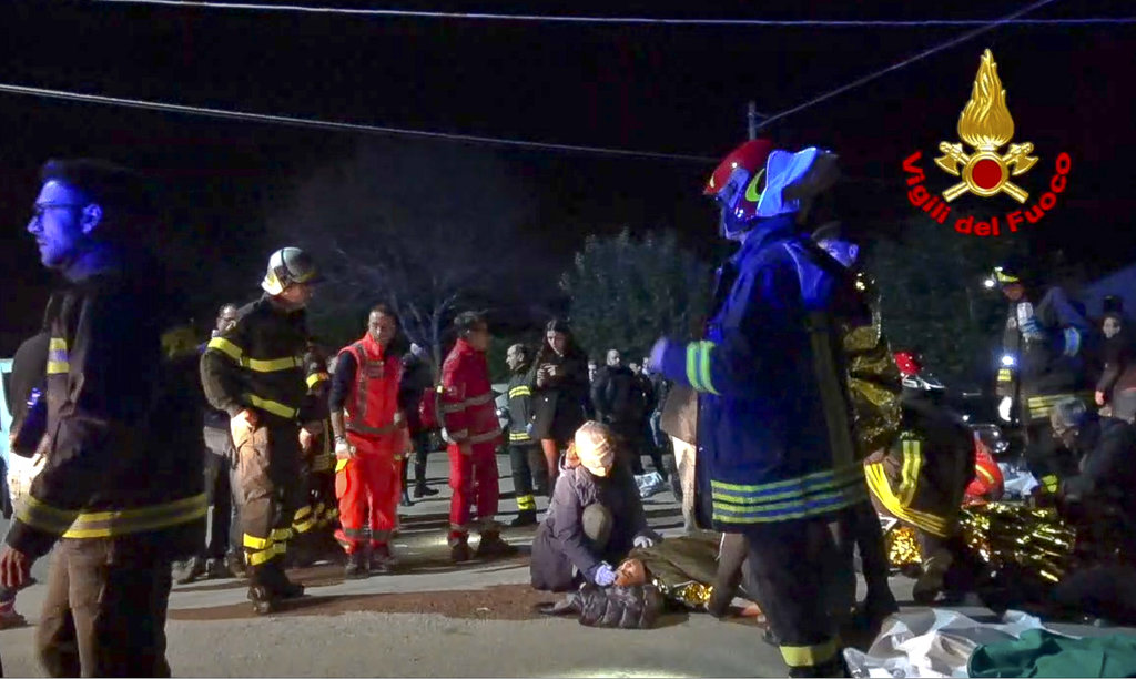 In this frame taken from video rescuers assist injured people outside a nightclub in Corinaldo early on Saturday.