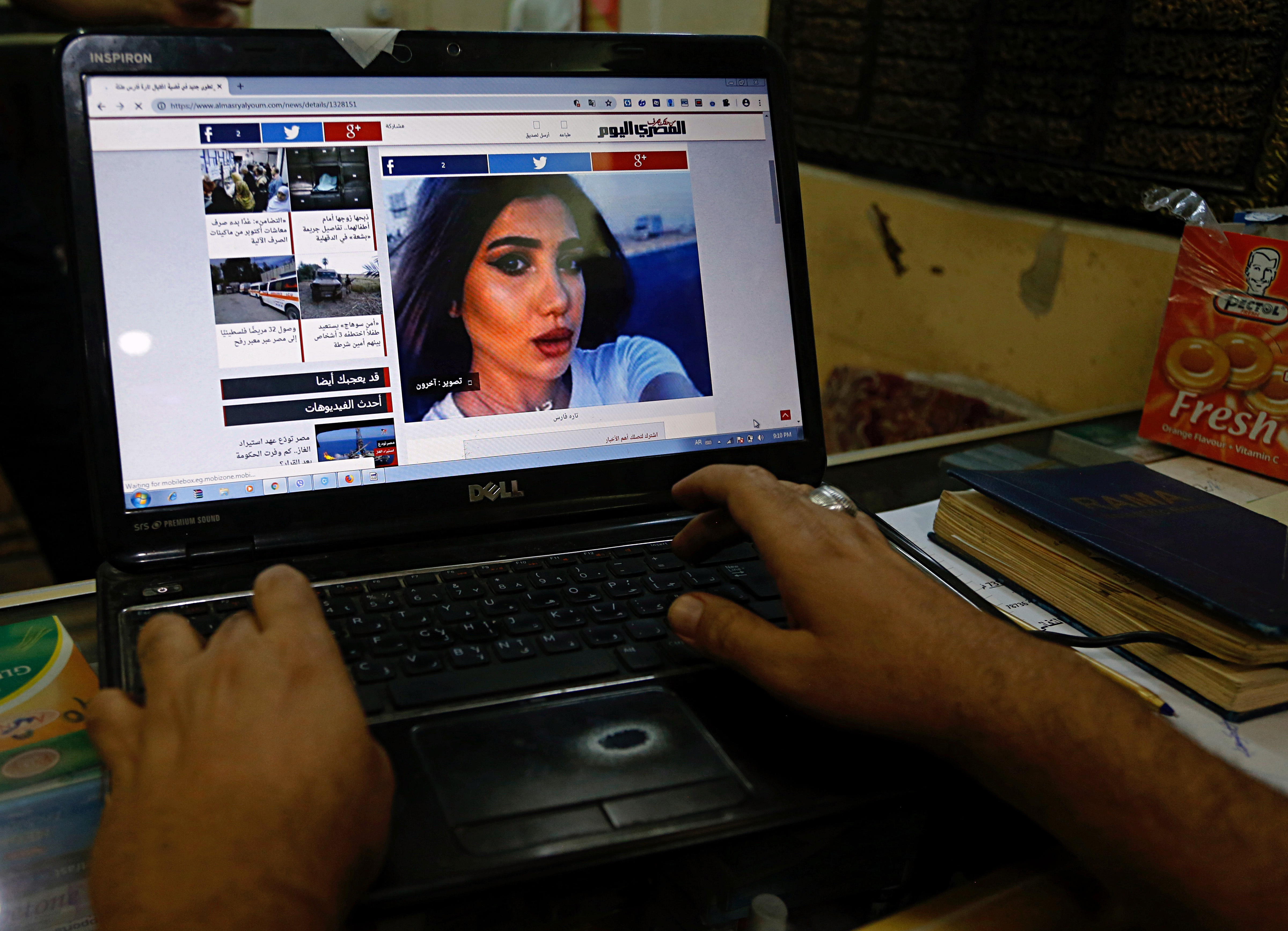 A fan of Tara Fares follows the news after her assassination, at a shop in Baghdad, Iraq.