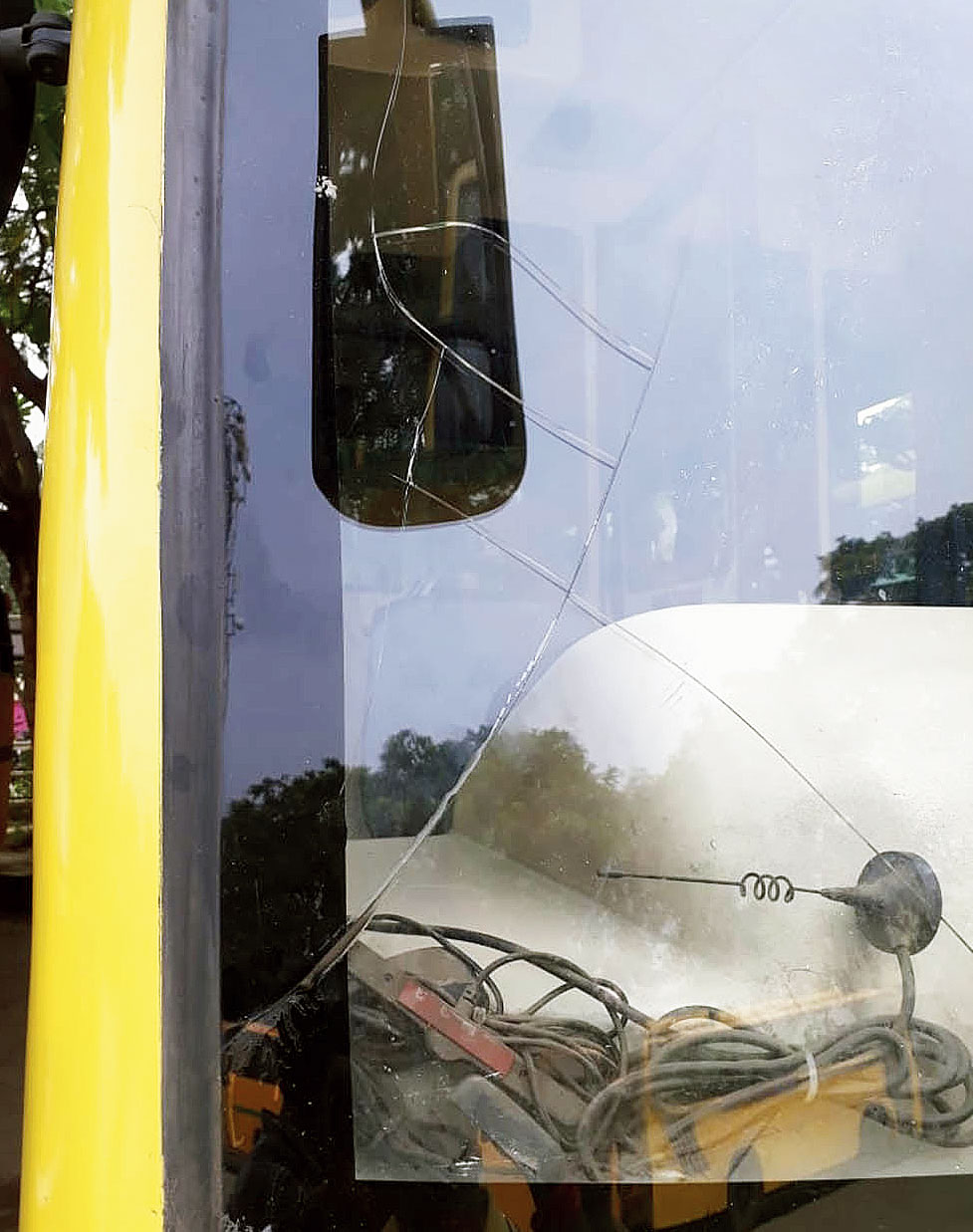 The broken windshield of the bus.