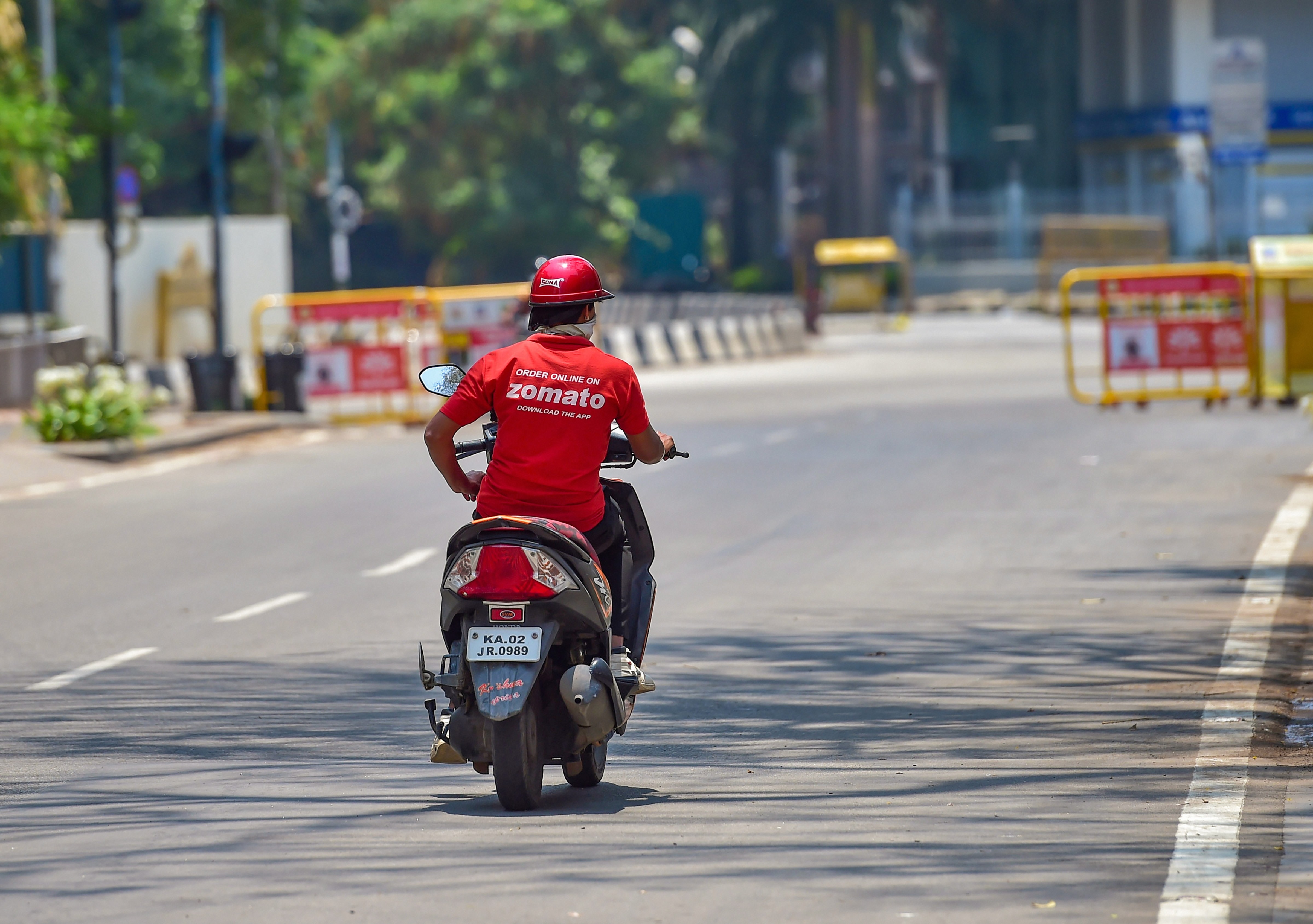 A food delivery man is seen on a deserted road during a nationwide lockdown imposed in the wake of novel coronavirus, in Bengaluru, Saturday, April 11, 2020.
