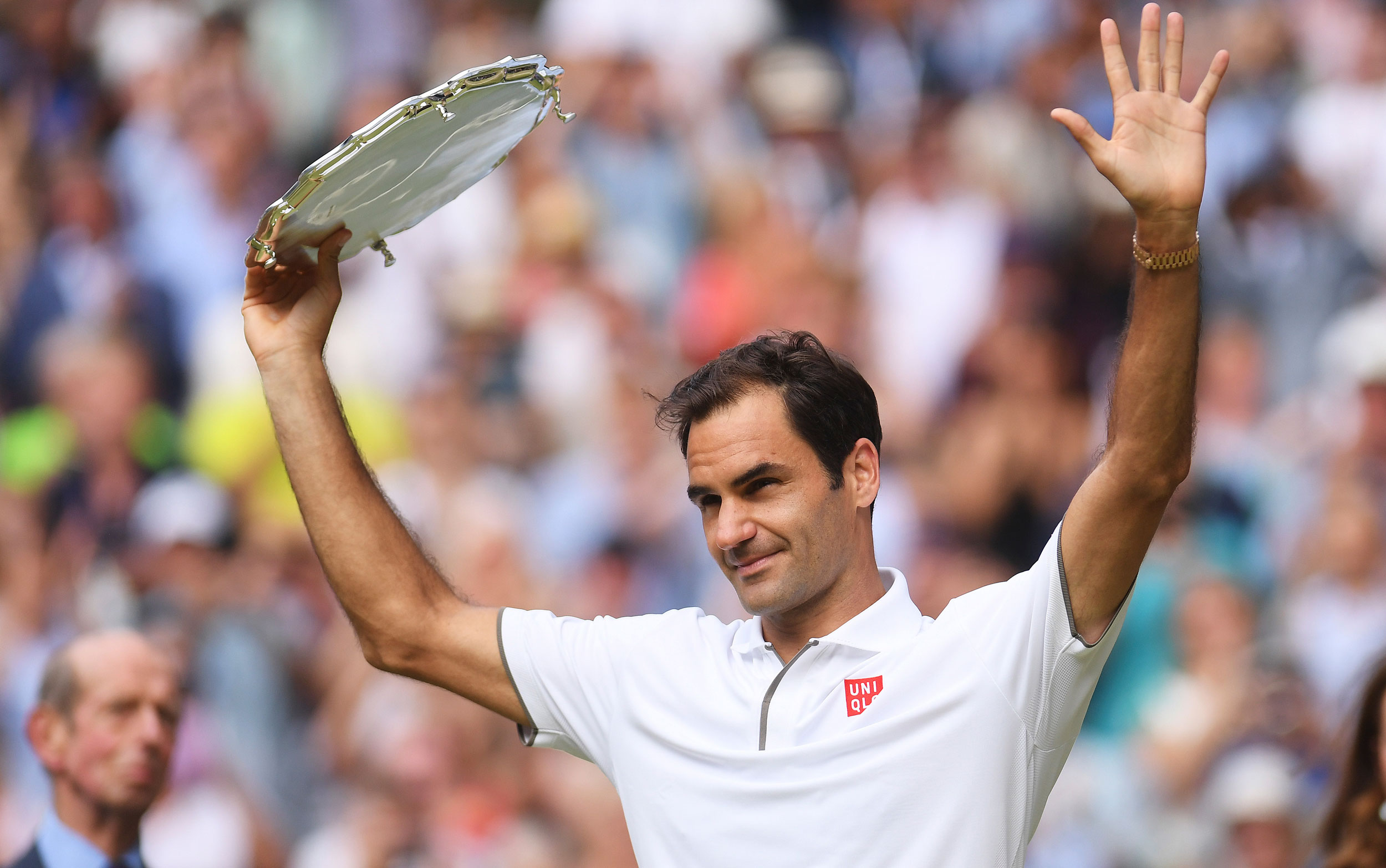 Roger Federer holds up the runners up trophy after he was defeated by Djokovic during the men's singles final match of the Wimbledon Tennis Championships in London, on July 14, 2019.