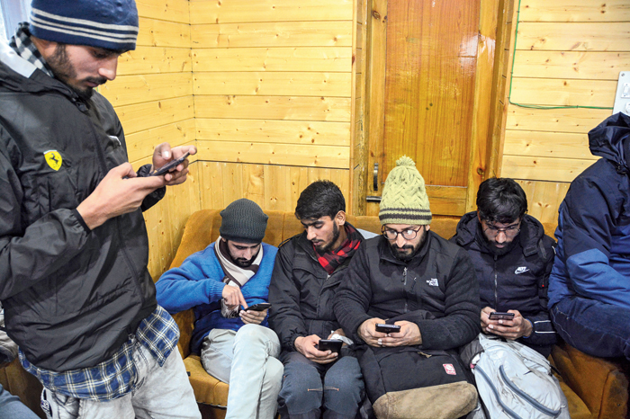 Journalists use their phones at the media facilitation centre in Srinagar