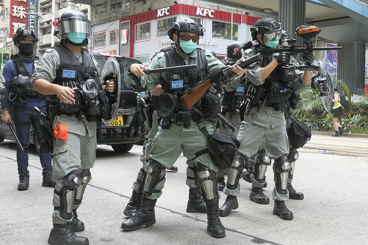 Riot police officers fire tear gas at protesters in Hong Kong. 
