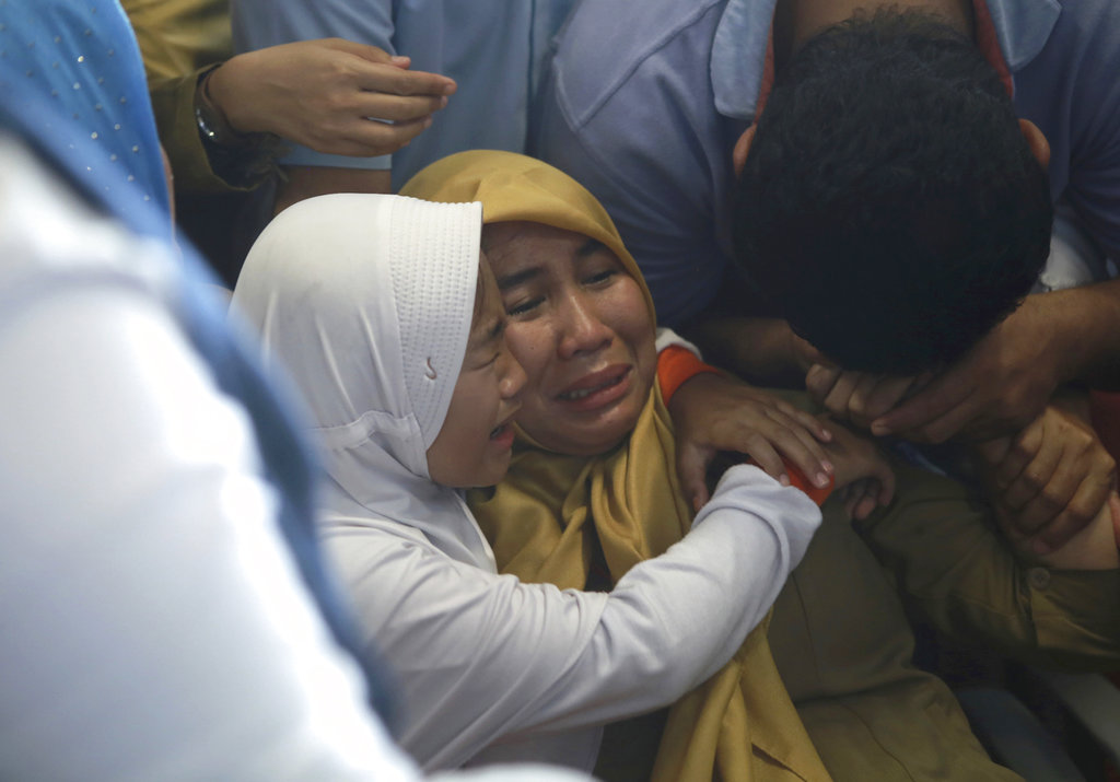 Relatives of passengers comfort each other as they wait for news on the Lion Air plane at Depati Amir Airport in Pangkal Pinang, Indonesia, on Monday.