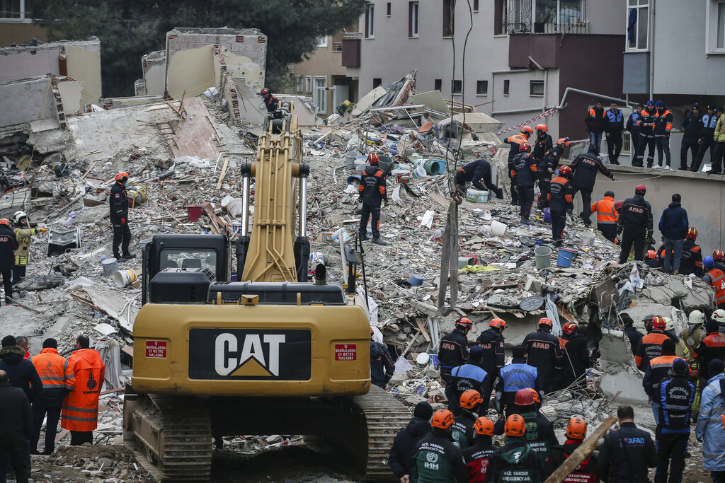 Rescue workers try to remove rubble from the building on Thursday.