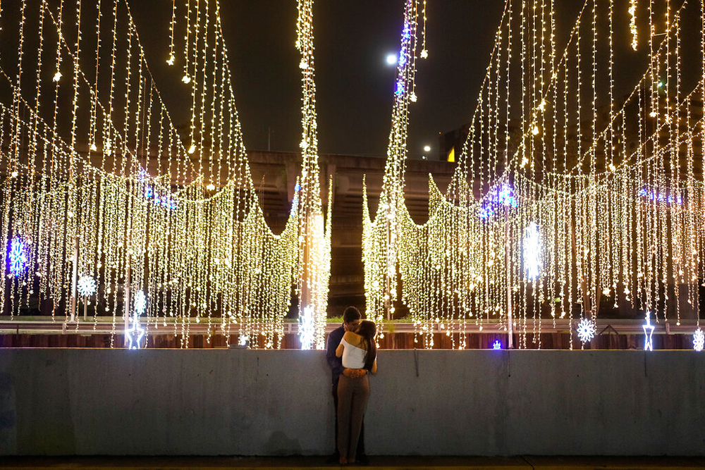 A couple kisses near Christmas lights strung over El Guaire river in Caracas, Venezuela, on December 18