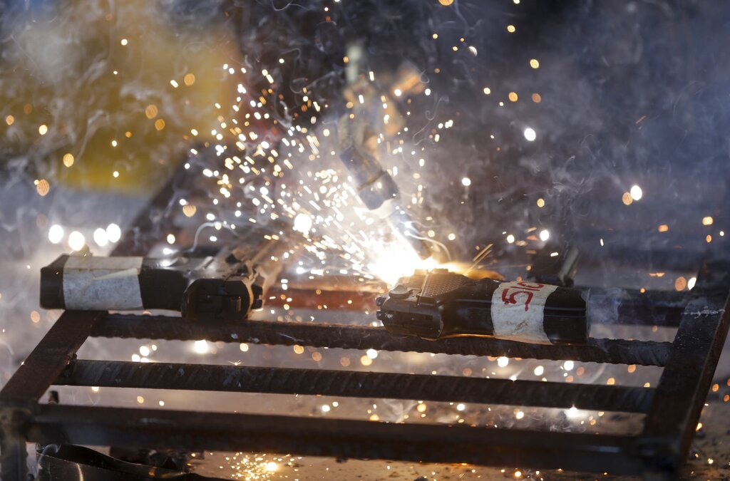 A police officer cuts a pistol in half with a torch during a weapons destruction presentation in Panama City on Thursday