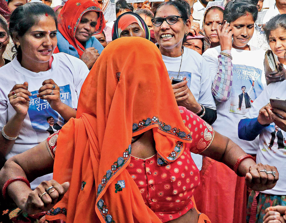 A woman celebrates the Congress victory in Rajasthan on Tuesday.