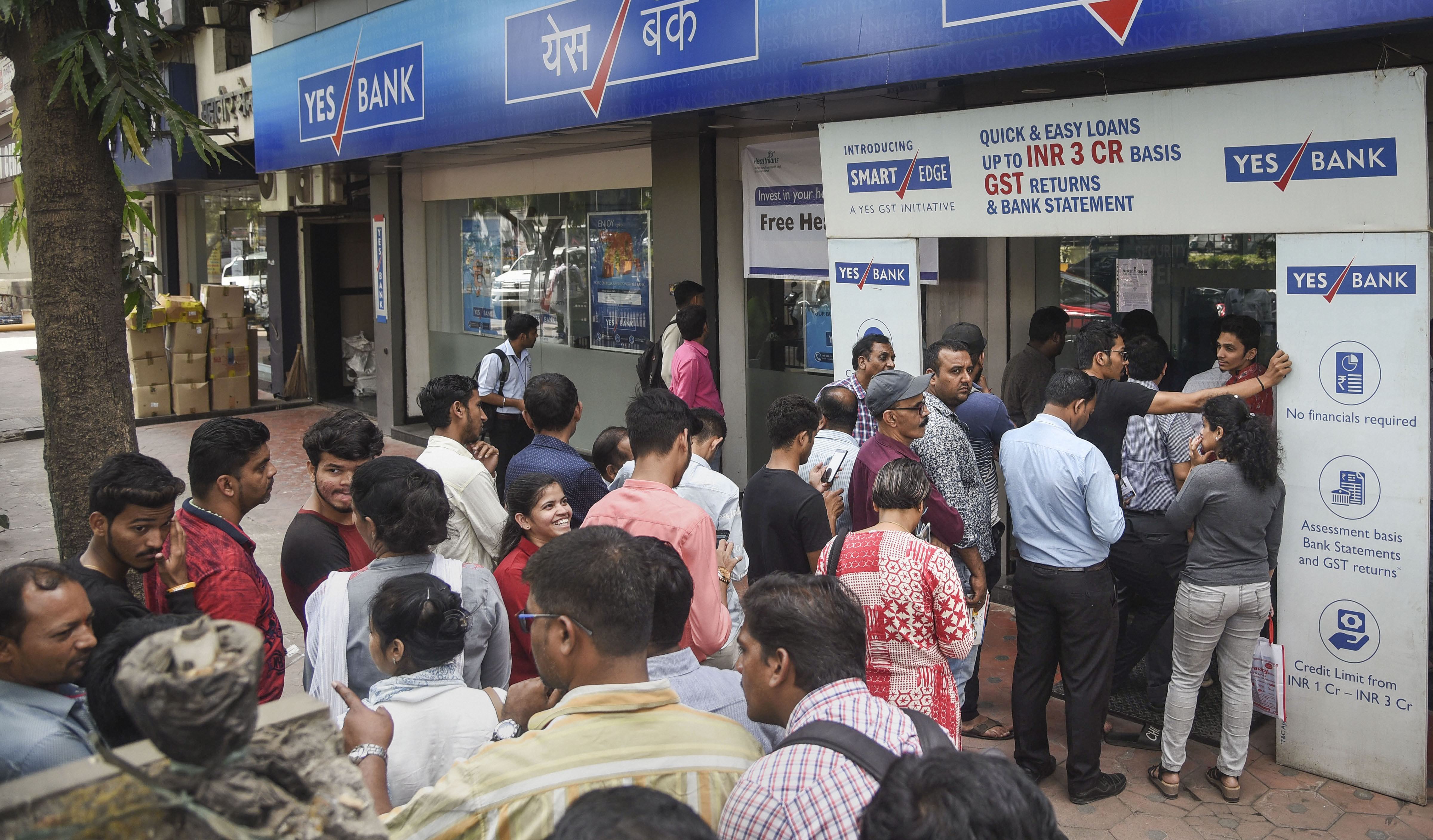 Account holders stand in a queue to withdraw money from Yes Bank at Vashi in Navi Mumbai, Friday, March 6, 2020