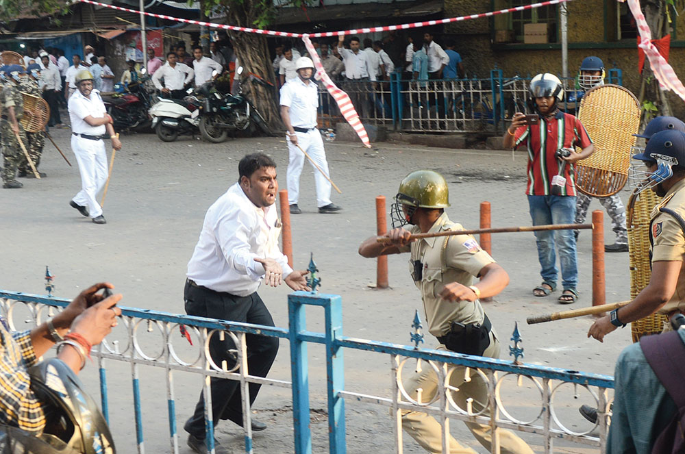 Police lathi charges a lawyer during a clash between lawyers and employees of the Howrah Municipal Corporation on Wednesday. Pictures by Bishwarup Dutta