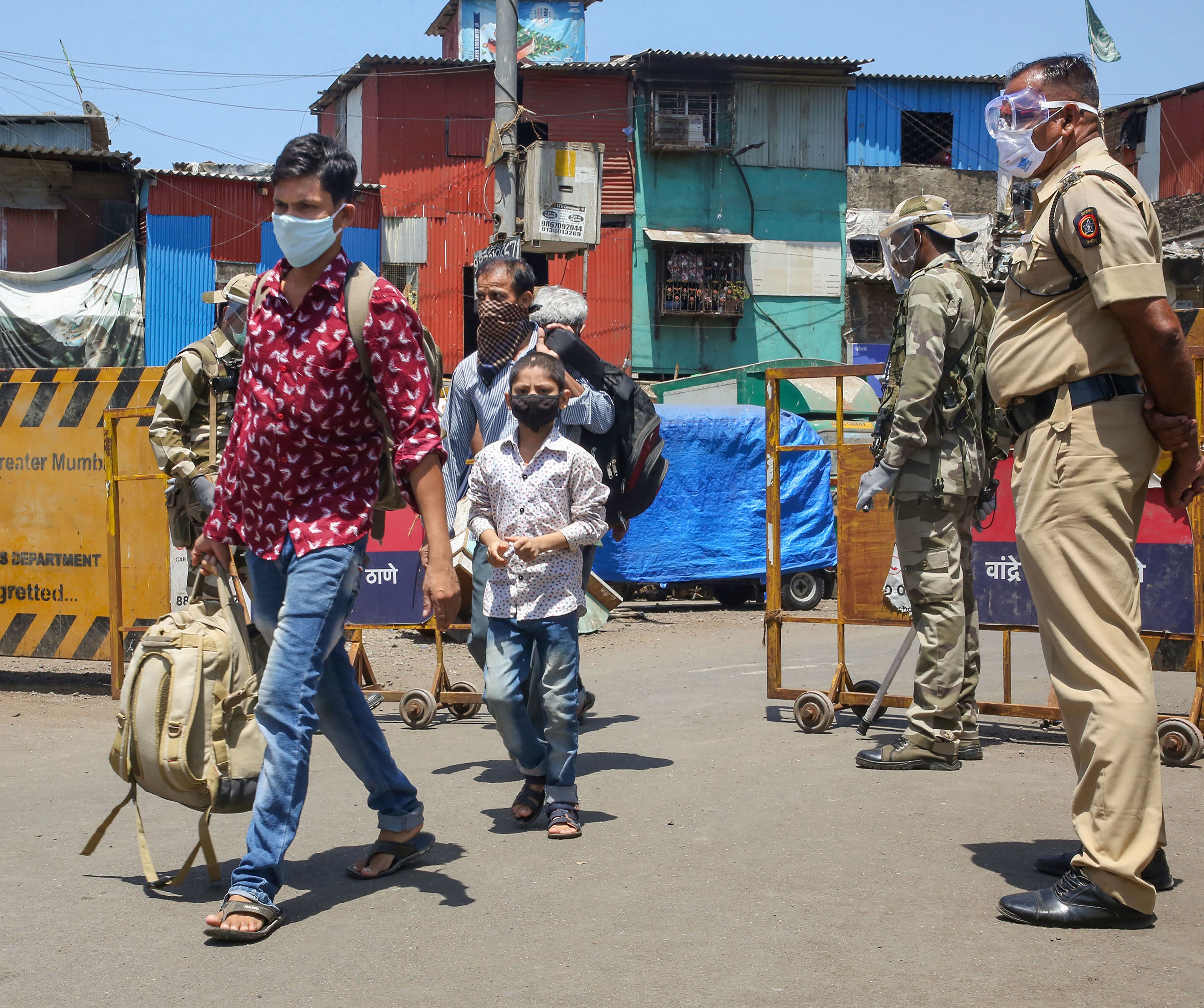 Security personnel stand guard as commuters walk past them in Mumbai