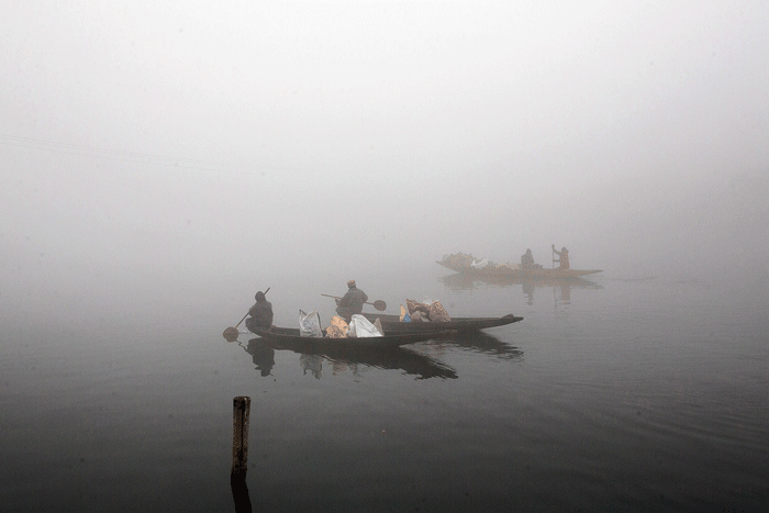 Boatmen on the Dal Lake on a cold Saturday morning in Srinagar
