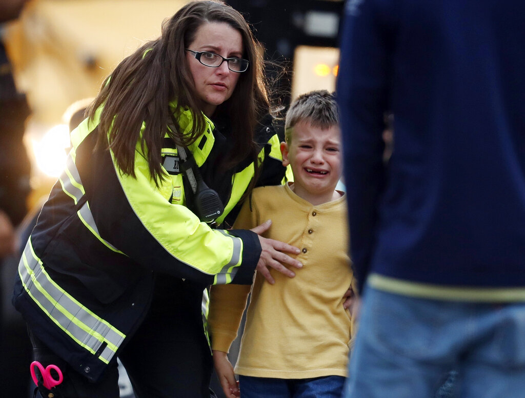 Officials guide students off a bus and into a recreation centre where they were reunited with their parents after the shooting.