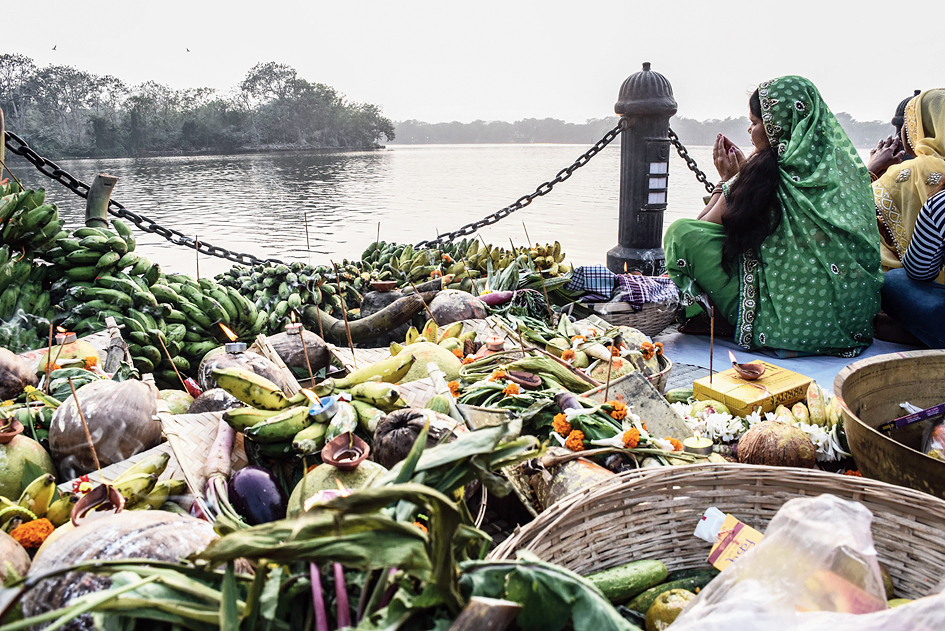 A devotee prays with offerings seated by Subhas Sarobar