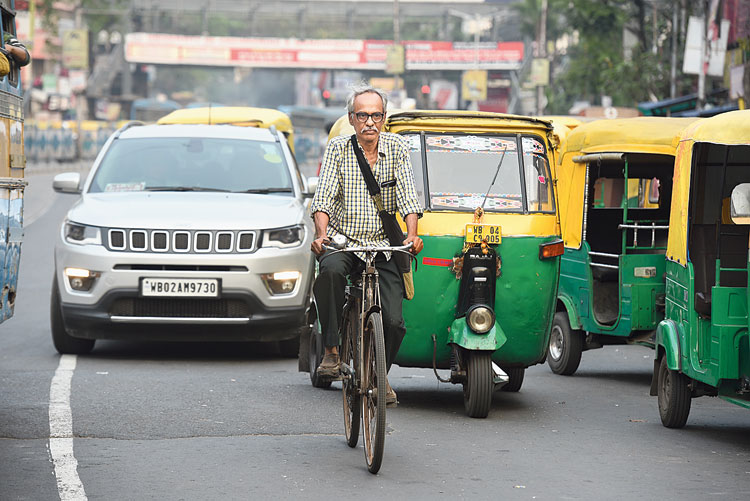 Raghu Jana rides his bicycle through a city road. 

