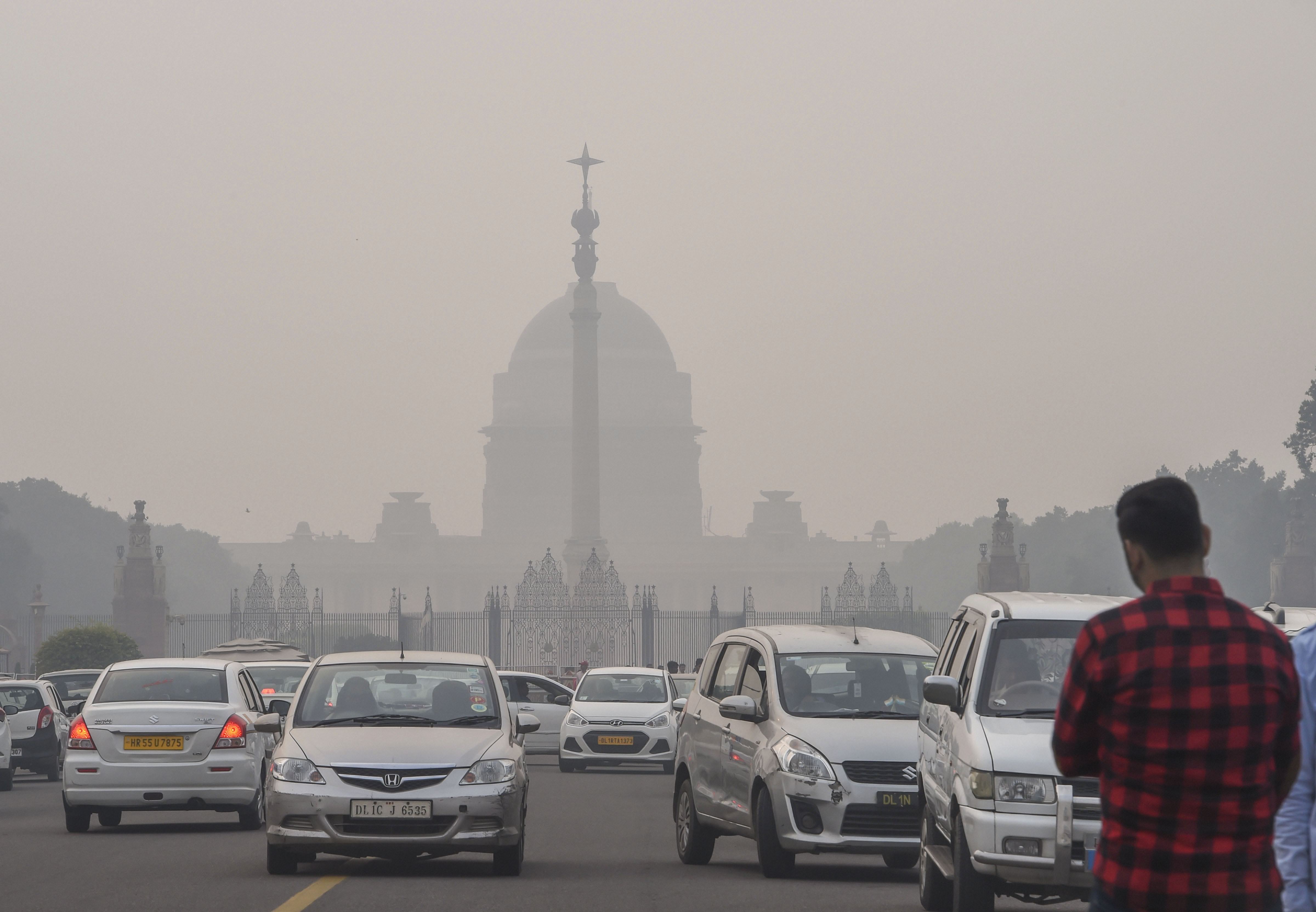  Vehicles ply on Rajpath as smog shrouds Rashtrapathi Bhawan, in New Delhi, Wednesday, November 13, 2019. 