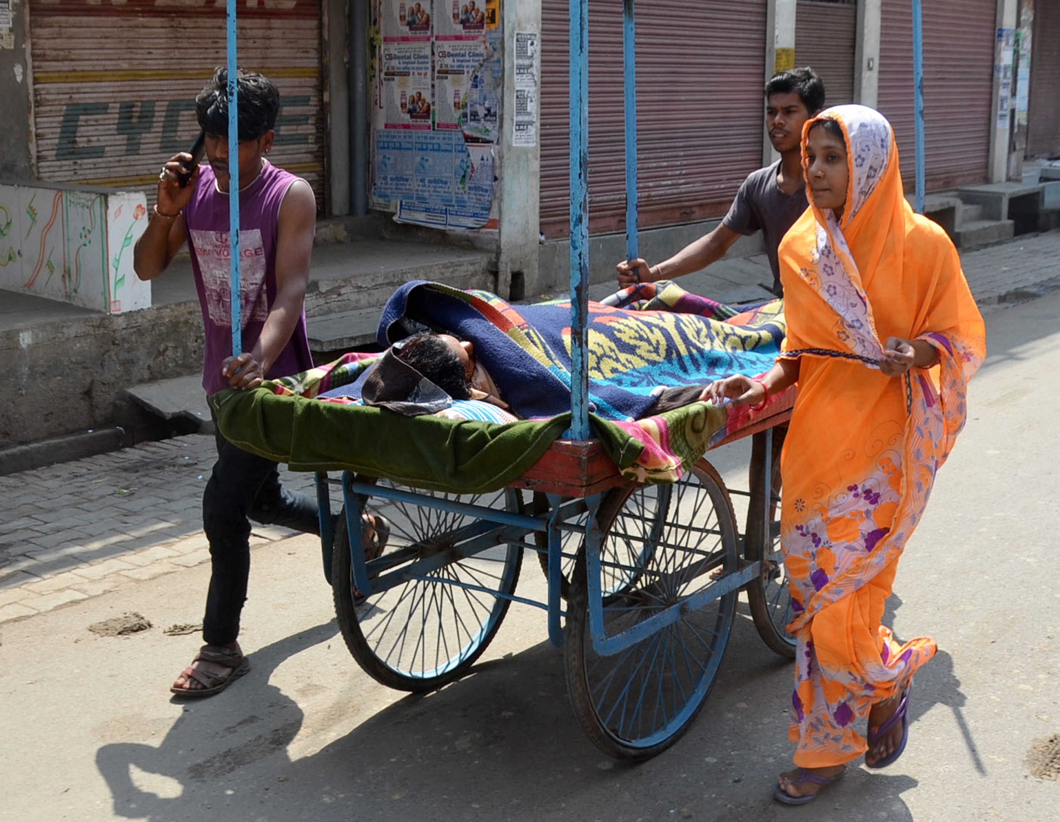 Family members carry a patient on a hand cart on their way to hospital during Janta curfew in the wake of coronavirus pandemic, in Mirzapur, Sunday, March 22, 2020