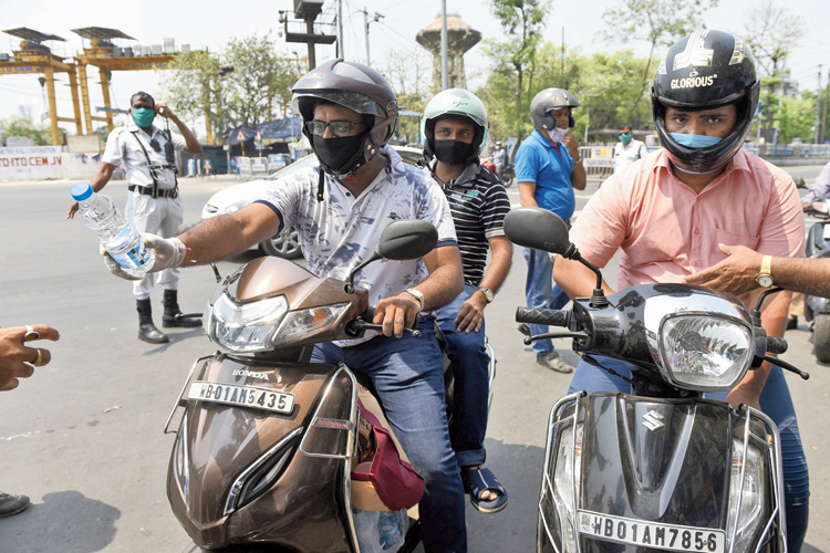 A group of people from Hazra distribute bottles of water to policemen in Esplanade. Pictures by Sanat Kr Sinha and Gautam Bose