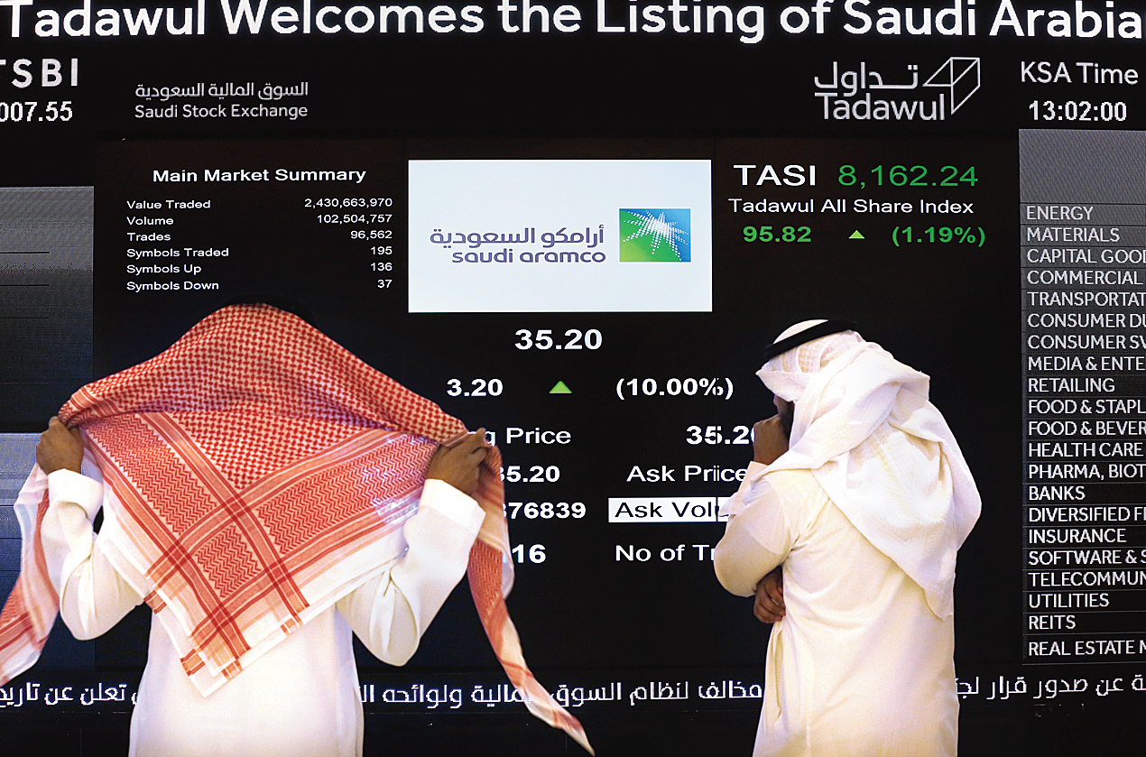 People look at the screen during Aramco’s debut on the stock exchange. 
