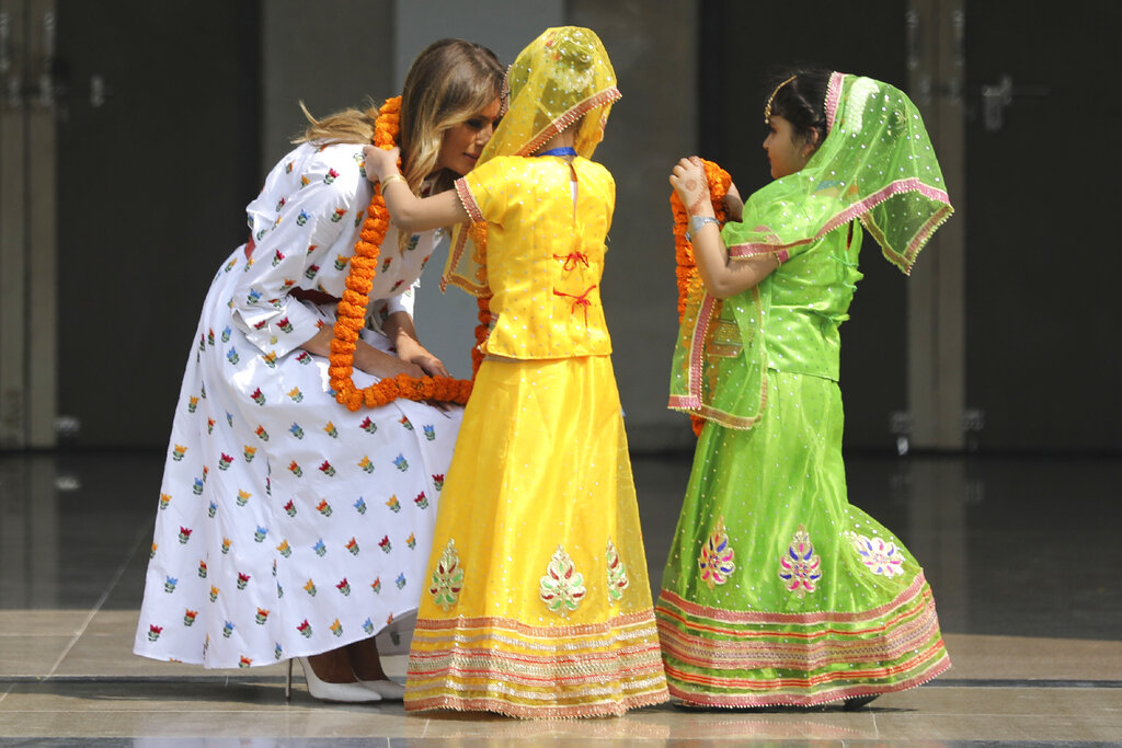 US first lady Melania Trump is garlanded by two children at Sarvodaya Co-Educational Senior Secondary School in New Delhi