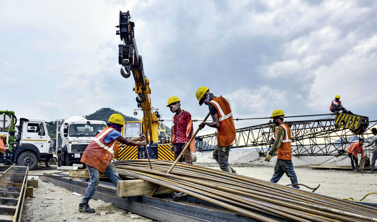Labourers work at a bridge construction site along the Brahmaputra in Guwahati on Wednesday during the lockdown. 
