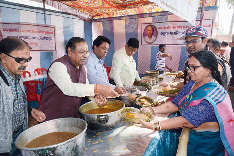 Members of Chandulal Bhalotia Social Welfare Trust feed people on the occasion of Makar Sankranti at Domuhani in the steel city on Wednesday