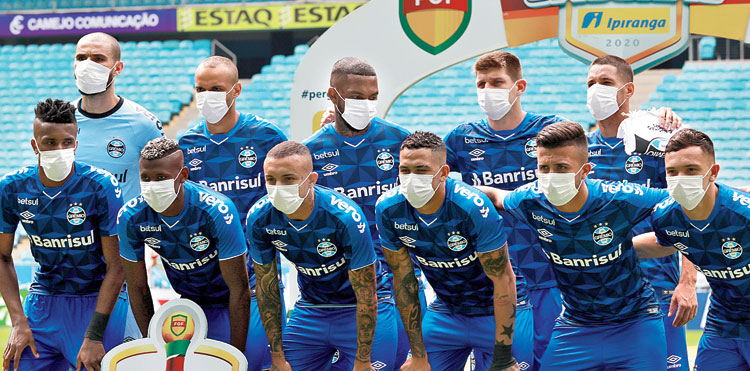 Gremio players take the field wearing masks against Sao Luiz in Porto Alegre, Brazil, on Sunday