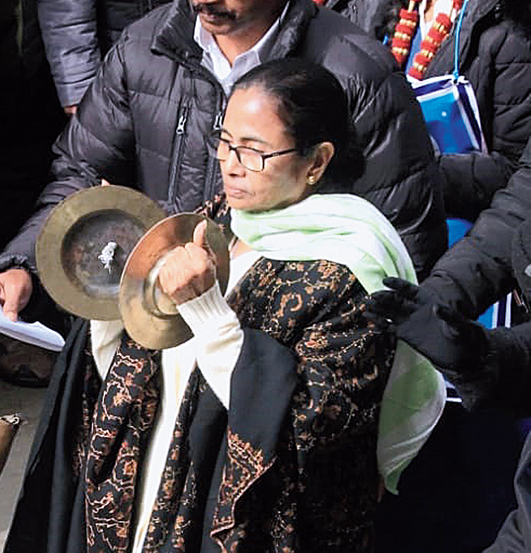 Mamata plays a musical instrument during the walk.