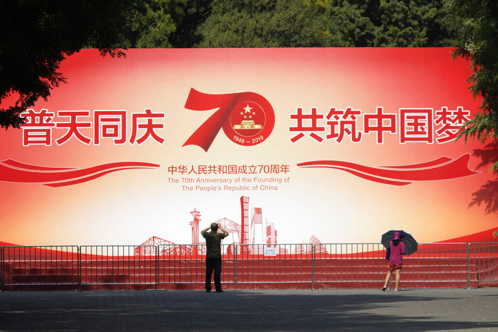 Visitors to a park look at a board with the words 'Celebrate the Chinese dream together' in Beijing on Friday