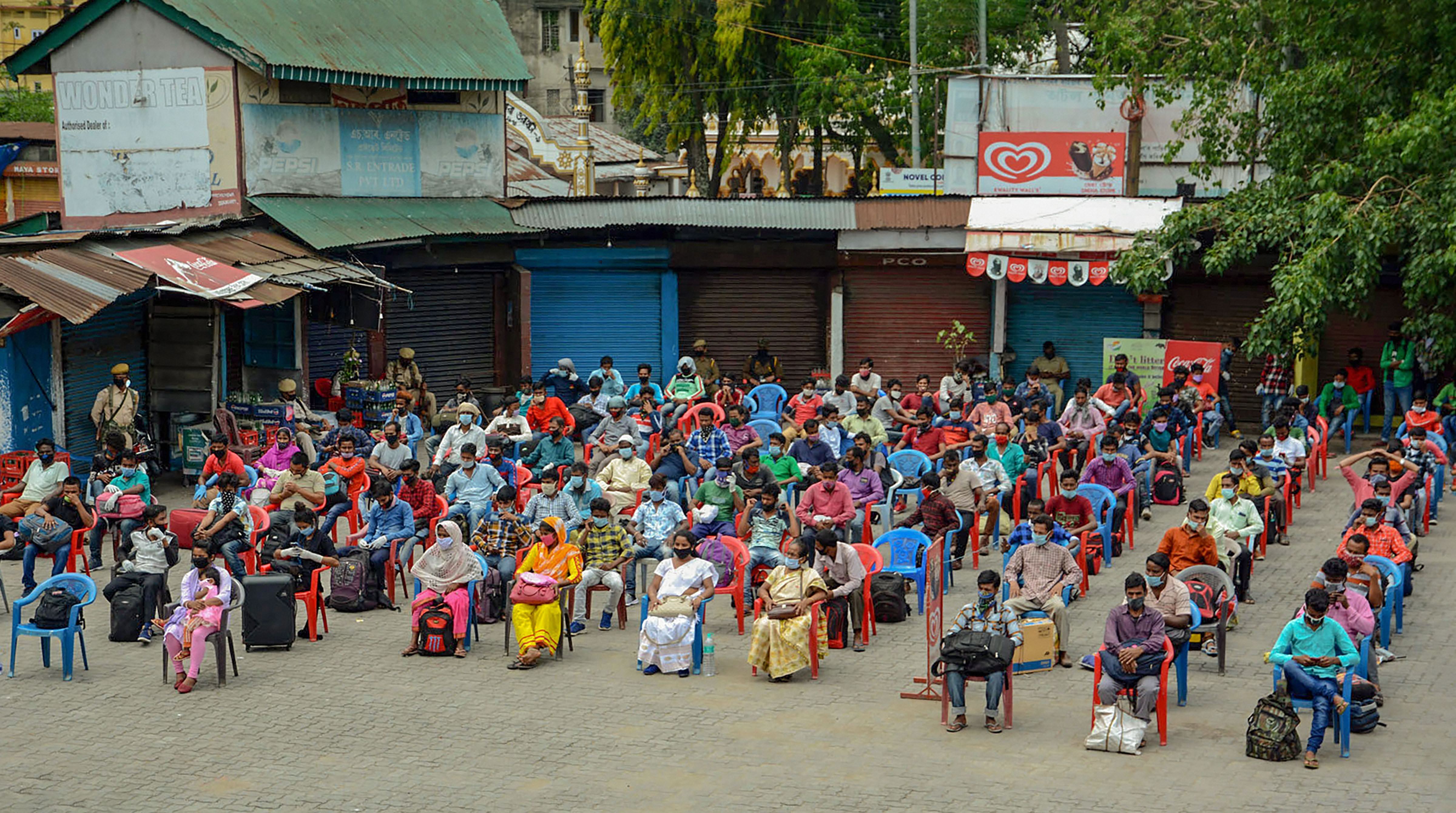 People maintain social distance as they wait to board a bus after state authorities extended the period of inter-district travel, during the nationwide lockdown to curb the spread of coronavirus, in Guwahati, Tuesday, April 28, 2020