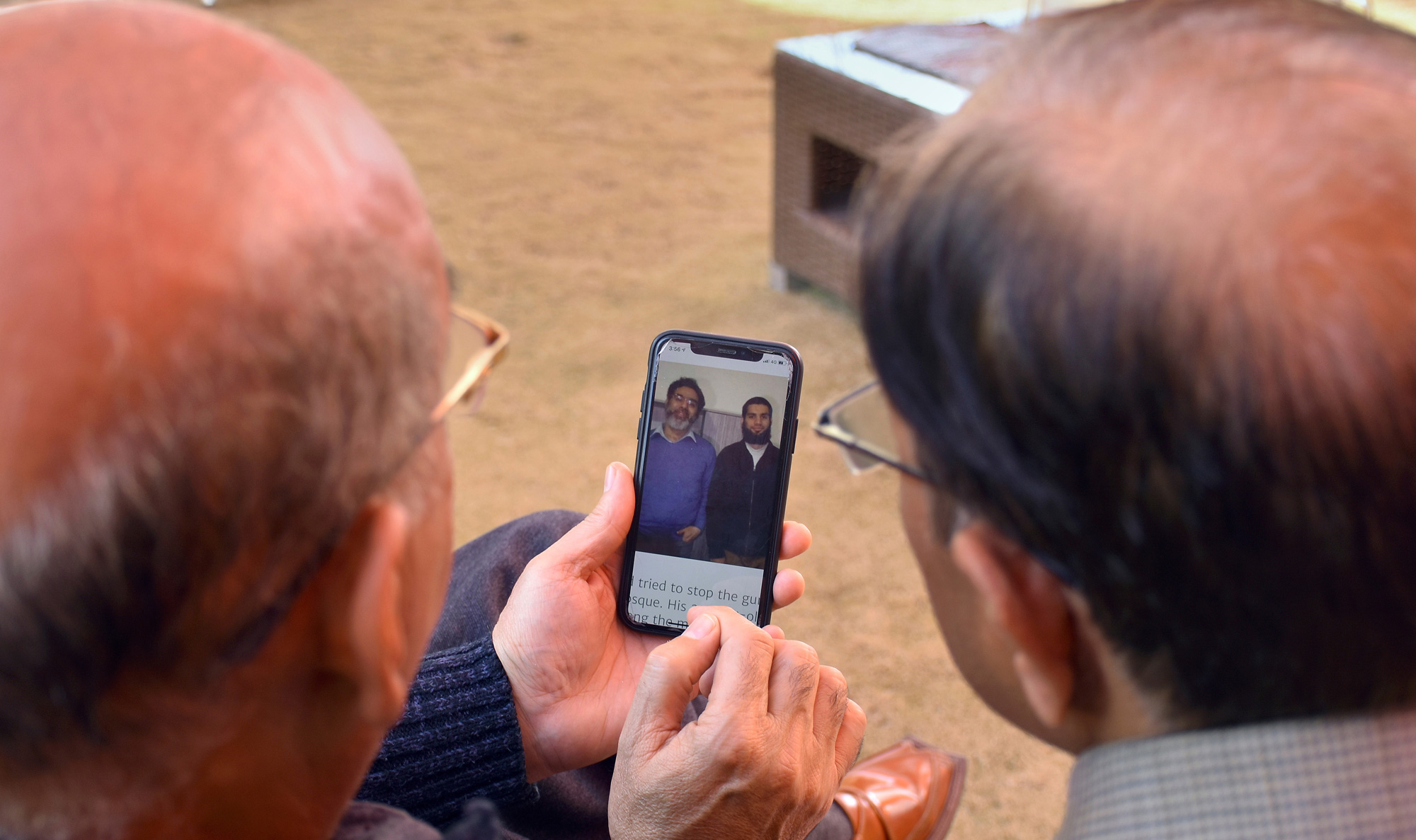 Relatives look the pictures of Pakistani citizen Rashid Naeem, and his son Talha Naeem, who were reportedly killed in the Christchurch mosque shooting, in a cell phone at their native home in Abbottabad, Pakistan on Saturday, March 16, 2019. 