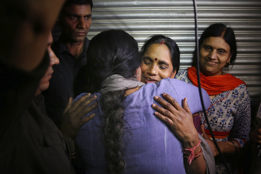 Asha Devi, mother of the victim of the fatal 2012 gang rape on a moving bus, facing camera, is embraced by an unidentified woman after the rapists of her daughter were hanged, in New Delhi, India, Friday, March 20, 2020. Four men were sentenced to capital punishment for the 2012 gang-rape of a 23-year-old physiotherapy student on a moving bus in New Delhi have been executed.