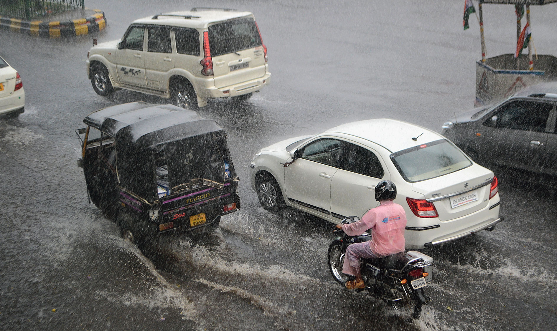 Commuters brave a downpour at Bistupur in Jamshedpur on Tuesday. 