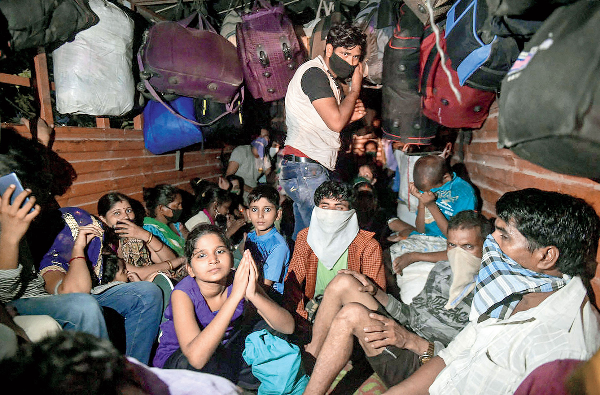 Migrants atop a truck on the Mumbai-Nashik highway on Monday.