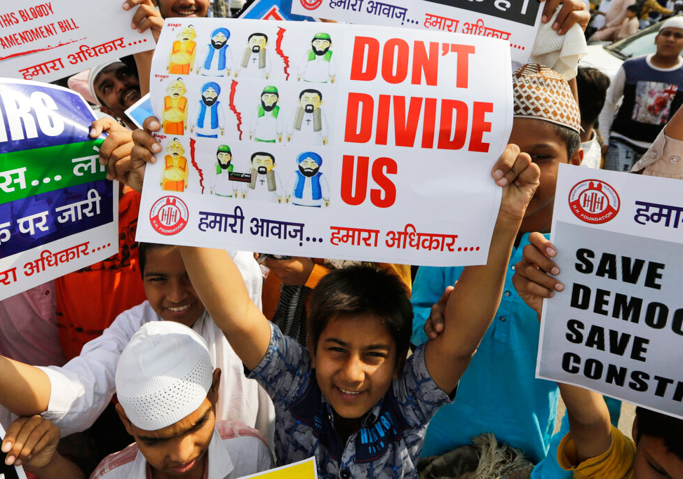 A boy holds a placard during a protest against Citizenship Amendment Act after Friday prayers in Ahmedabad, Friday, December 13, 2019.