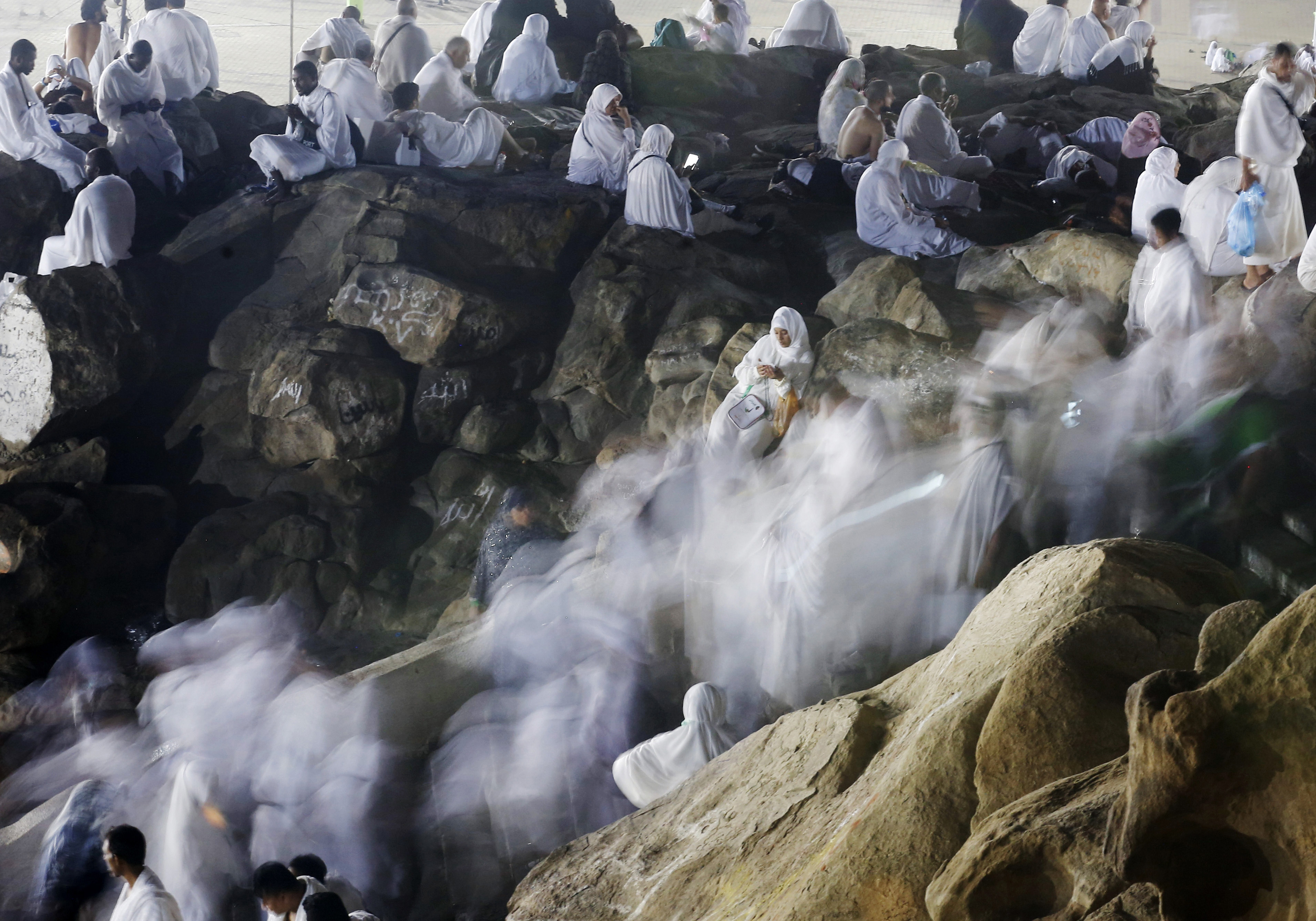 Muslim pilgrims make their way up a rocky hill known as Mountain of Mercy on the Plain of Arafat during the annual Haj pilgrimage in August 2019