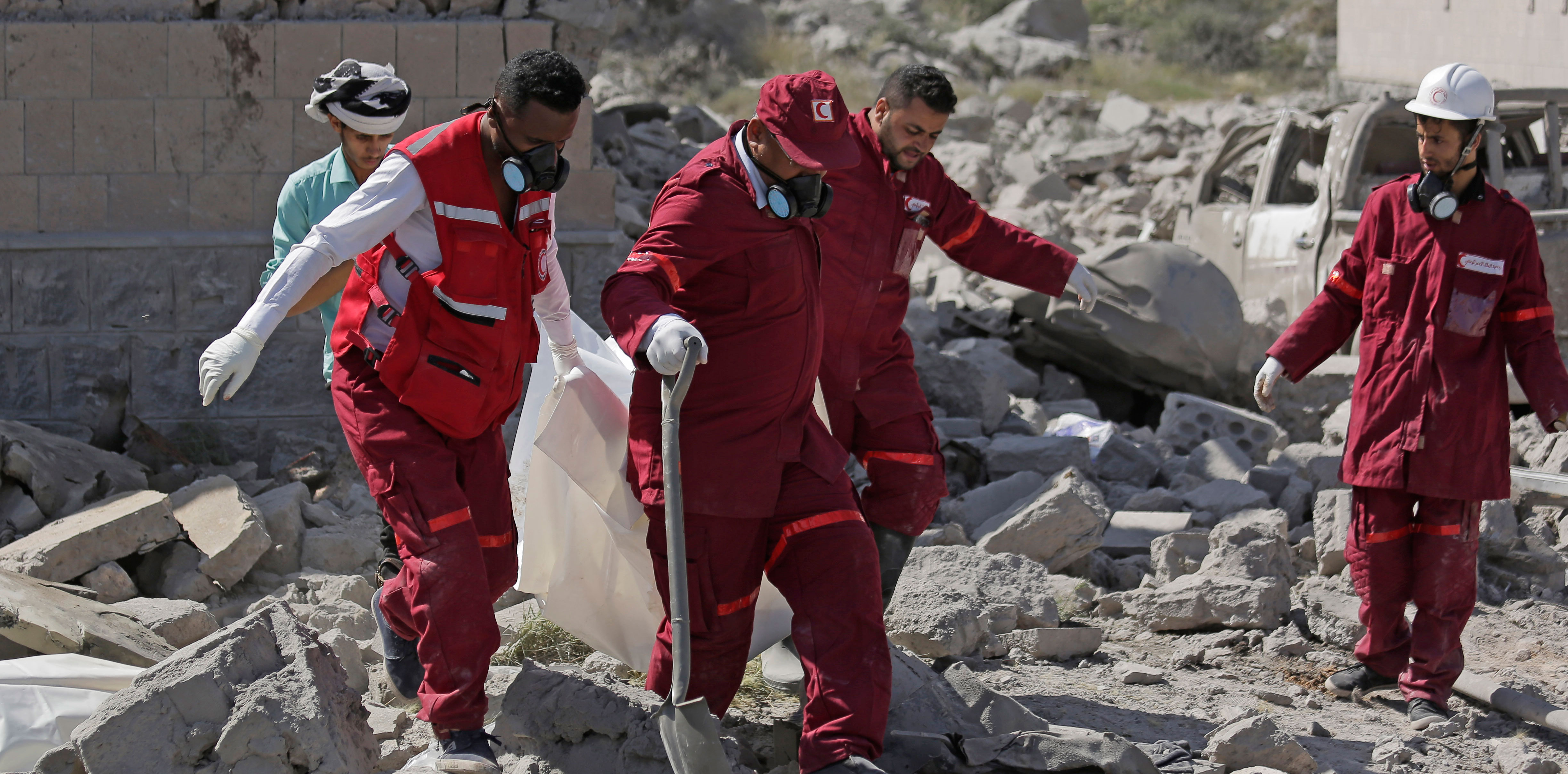 Rescue workers carry a body from a Houthi detention center destroyed by Saudi-led airstrikes that killed at least 60 people and wounding several dozen according to officials and the rebels' health ministry in Dhamar province, southwestern Yemen, on September 1, 2019.