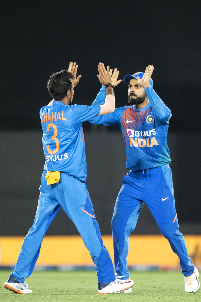 Indian captain Virat Kohli high fives Yuzvendra Chahal after he caught New Zealand's Kane Williamson out during their T20 International in Auckland, New Zealand, Sunday, January 26, 2020. 