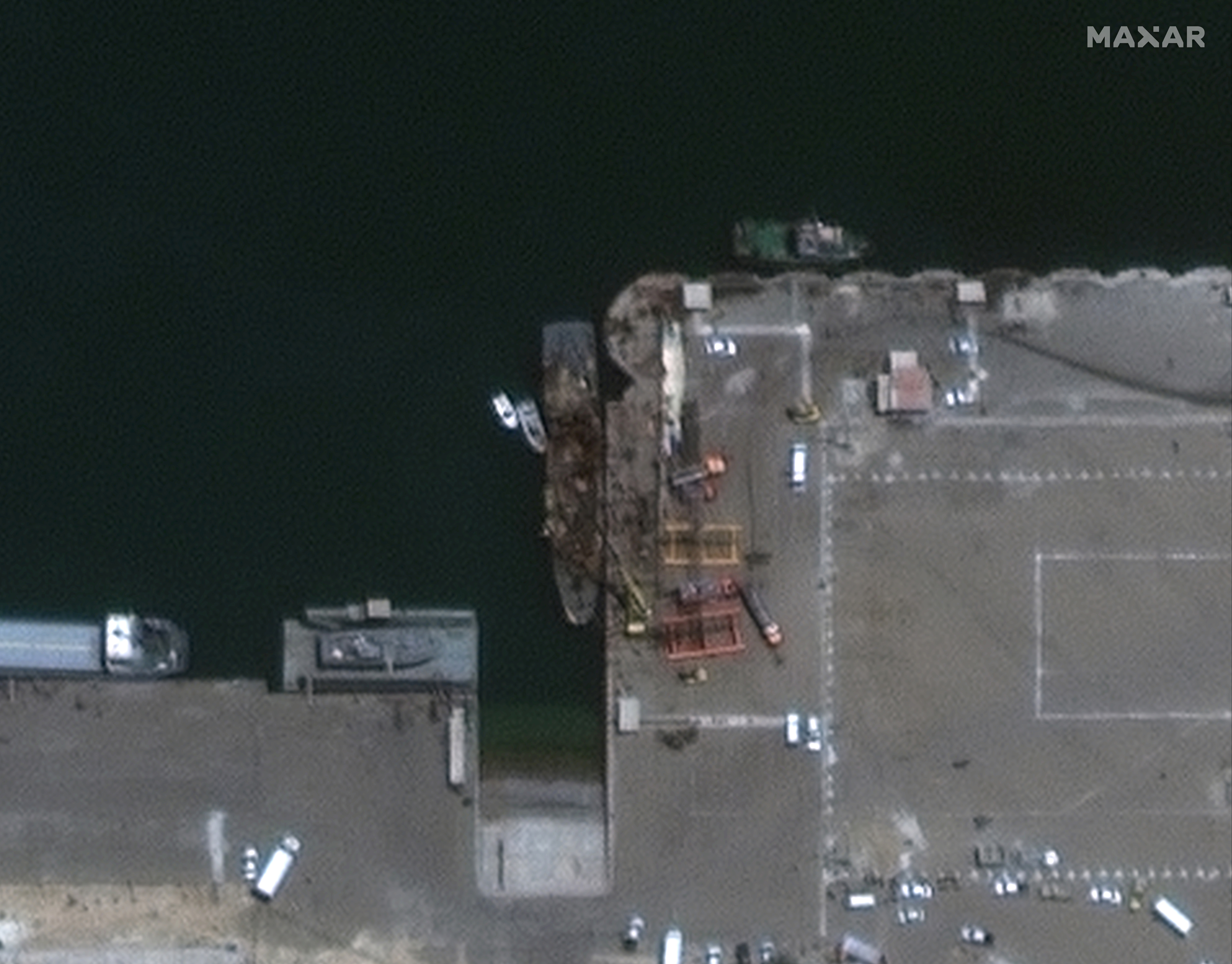 In this satellite photo provided by Maxar Technologies, the Iranian naval support vessel Konarak, center, is tied up at the port in Konarak, Iran