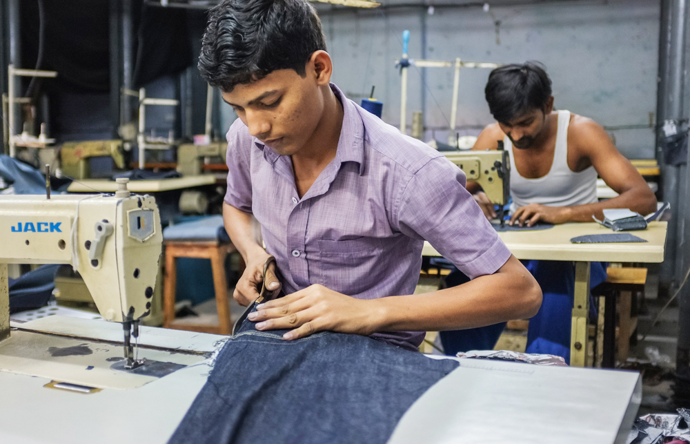 Workers sewing in a clothing factory in Dharavi slum, Mumbai.